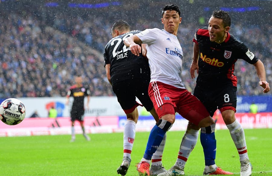 Hwang schirmt den Ball gegen zwei Regensburger ab.