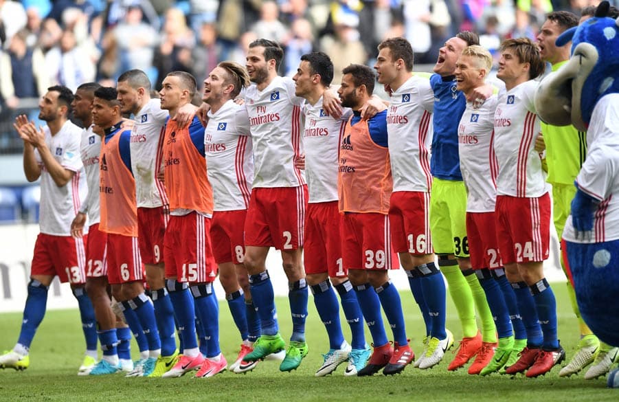 Die Mannschaft feiert mit einer Welle vor der Kurve.