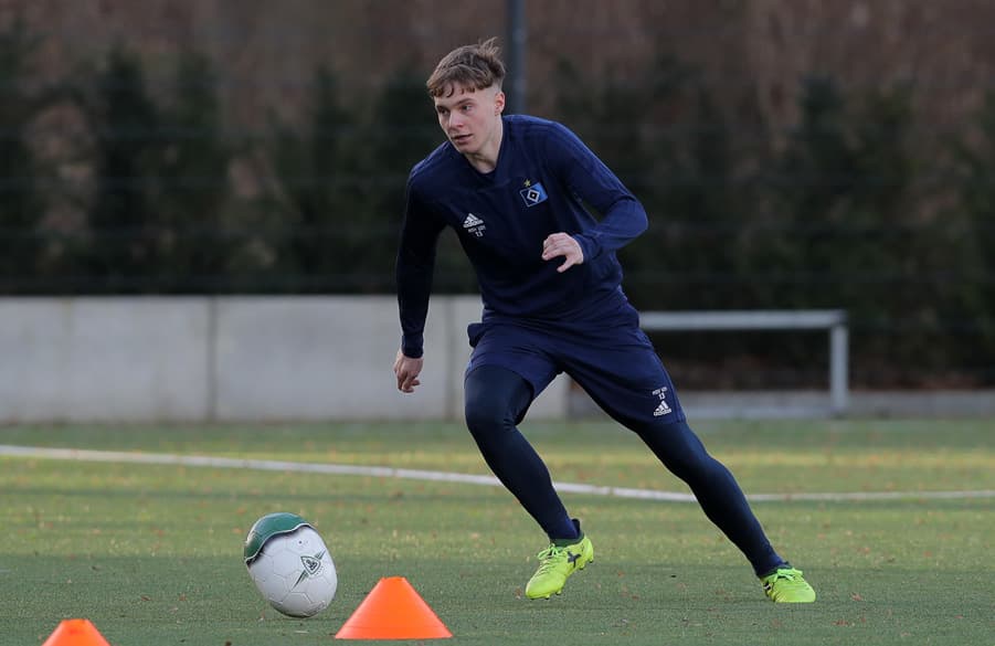 Niklas Schneider dribbelt mit einem eiförmigen Ball.