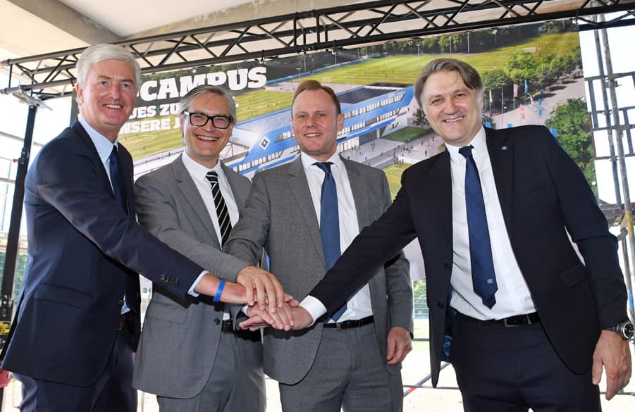 Bernhard Peters, Andy Grote, Alexander Otto und Dietmar Beiersdorfer stehen beim Richtfest zusammen und reichen sich die Hand.
