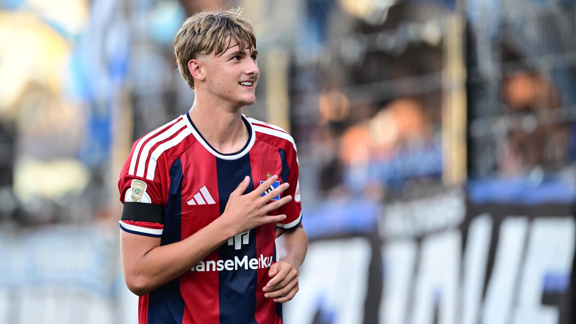 Louis Lemke hält nach seinem Debüttreffer dankend die rechte Hand flach auf die HSV-Raute