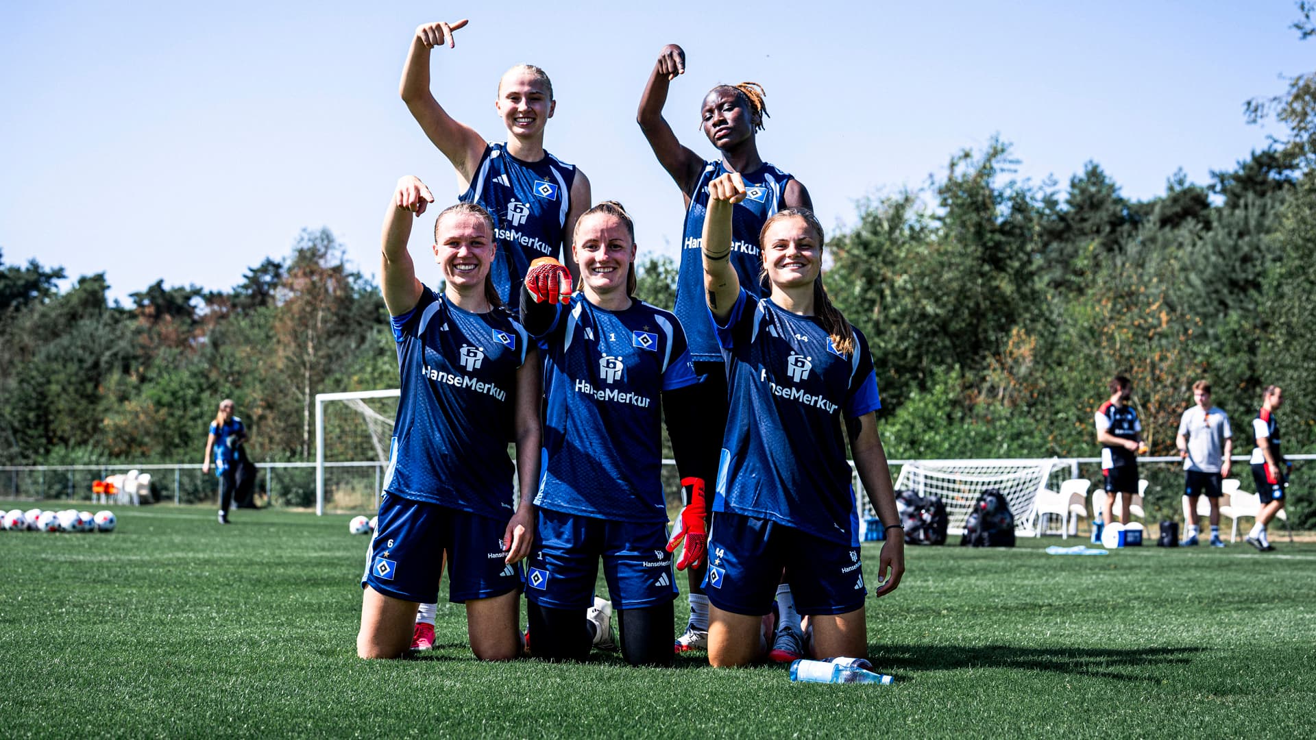 Fünf Spielerinnen der HSV-Frauen jubeln mit einer Zeigefinger-Geste Richtung Kamera nach einem gewonnen Trainingsspiel auf dem Trainingsplatz