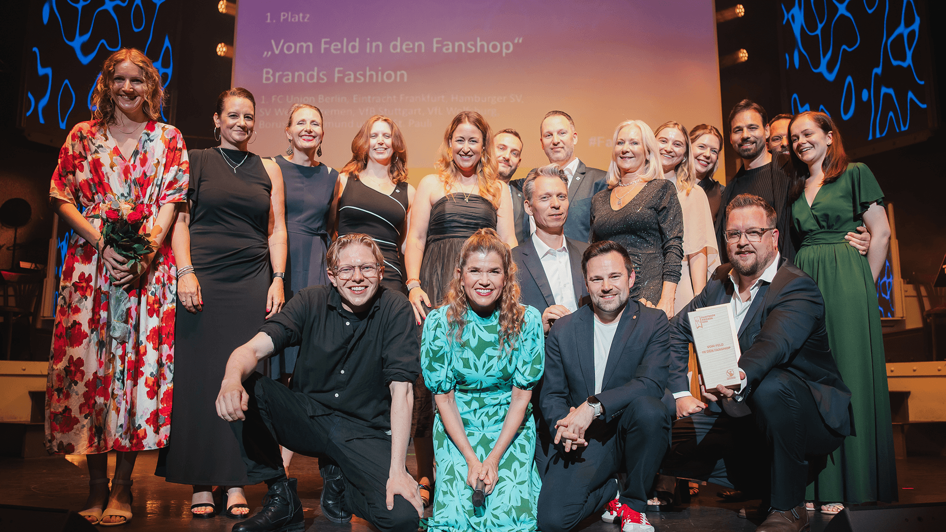 Mehrere Personen posieren mit Anke Engelke auf der Bühne.