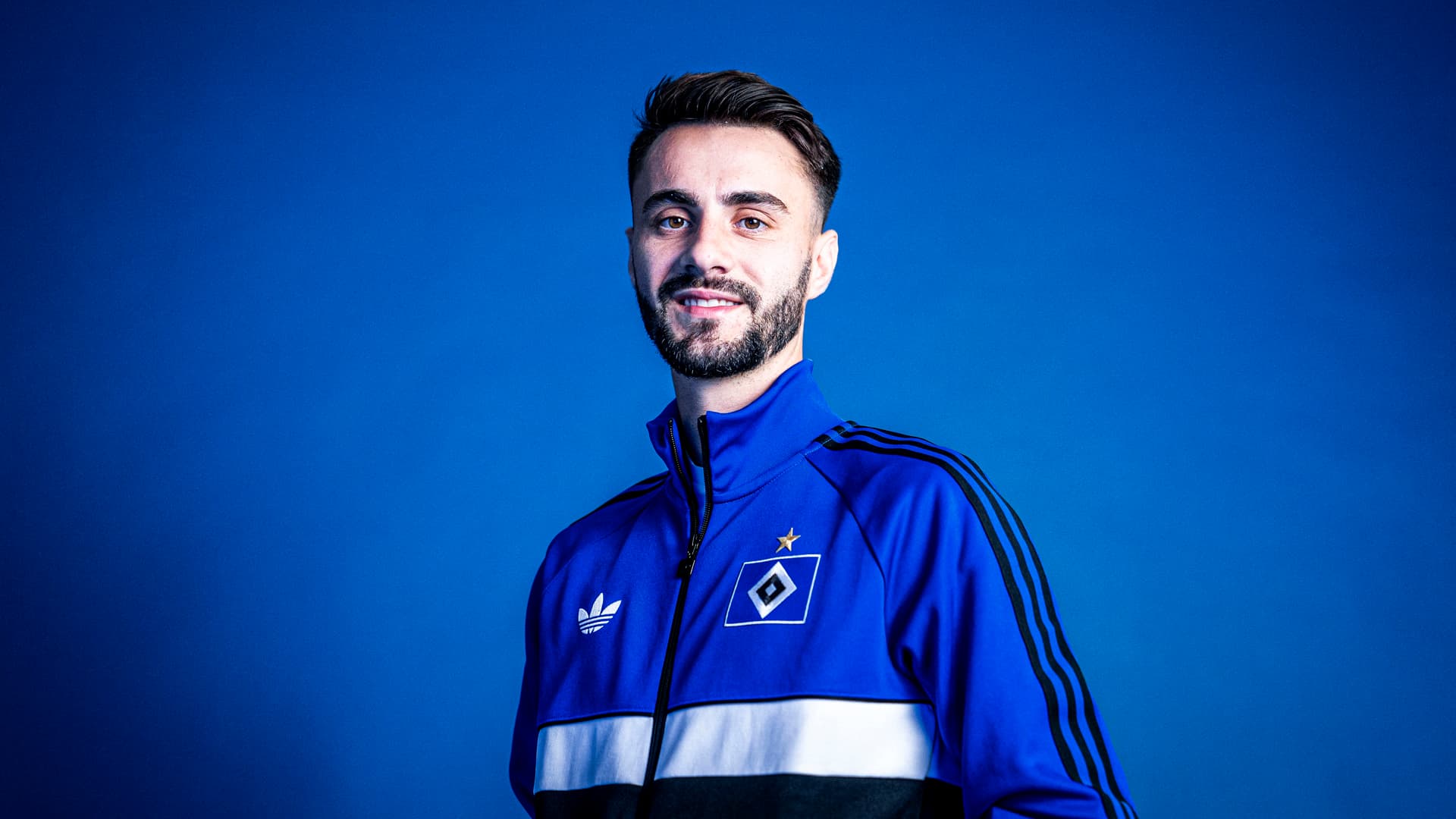 Fabio Vieira im Portrait vor einer blauen Rückwand
