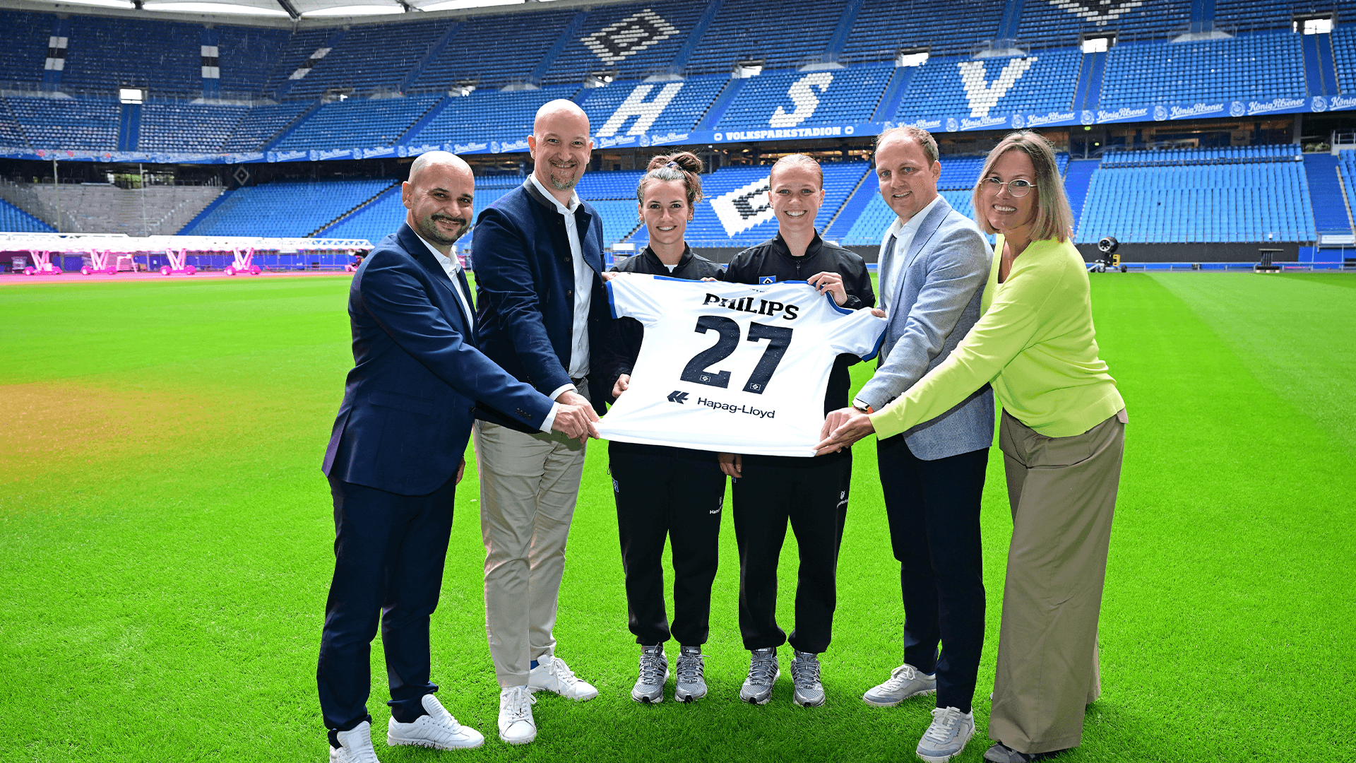 Vertreter des HSV und von Philips posieren mit Trikot.