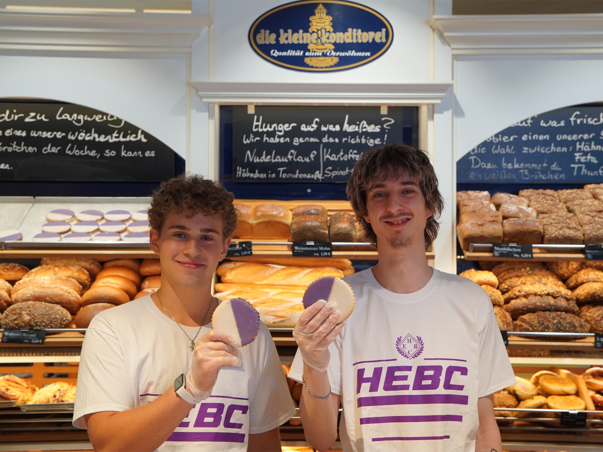 Zwei Bäckerverkäufer im HEBC-Shirt mit einem lila-weißen Hanseaten