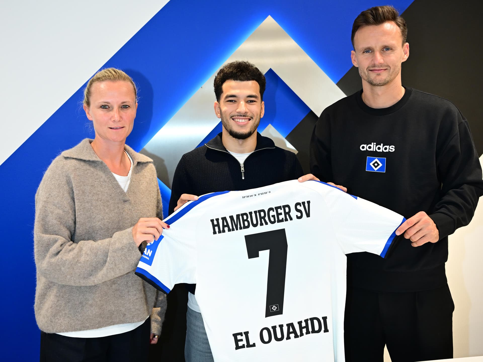 Kathleen Krüger und Claus Costa begrüßen Zugang El Ouahdi in ihrer Mitte. Gemeinsam halten die drei das Trikot mit der Nummer 7 hoch.