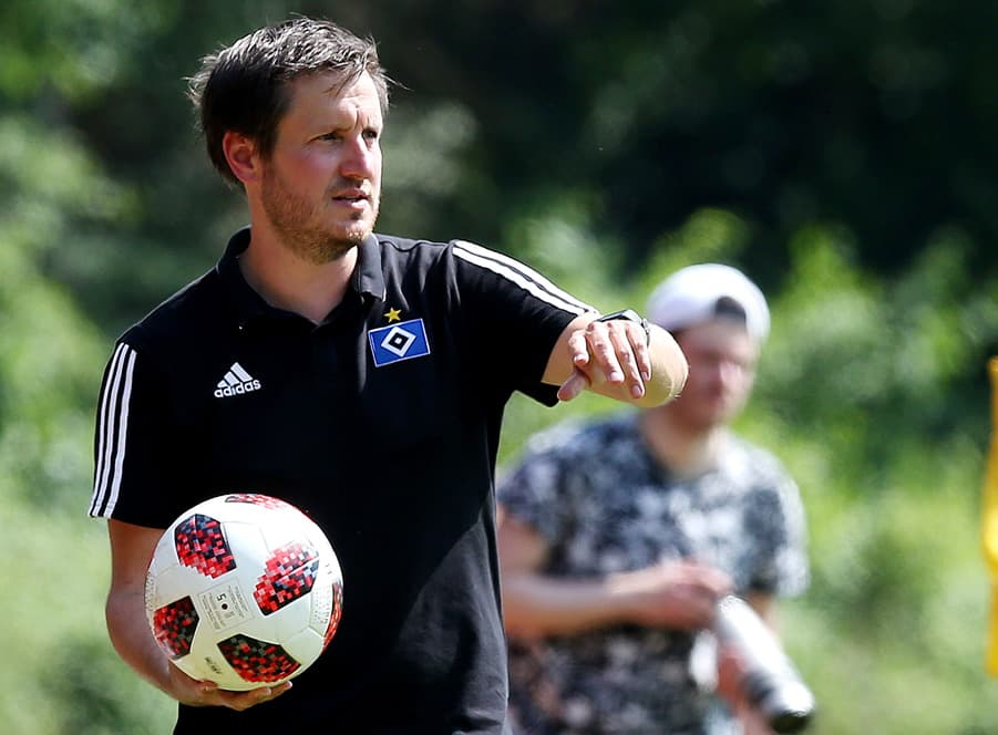 Hannes Drews steht mit einem Ball in der Hand an der Seitenlinie.