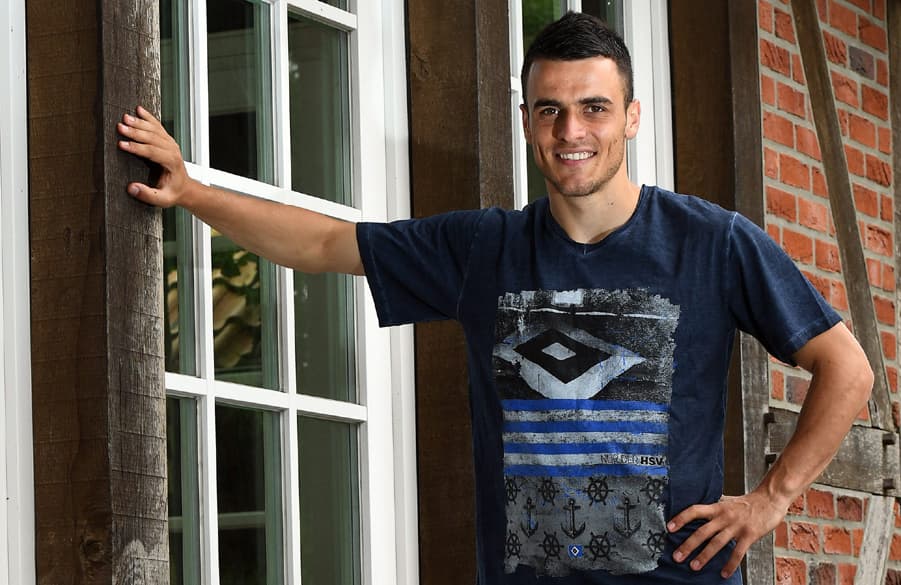 Kostic lehnt mit einer Hand an einer Wand.
