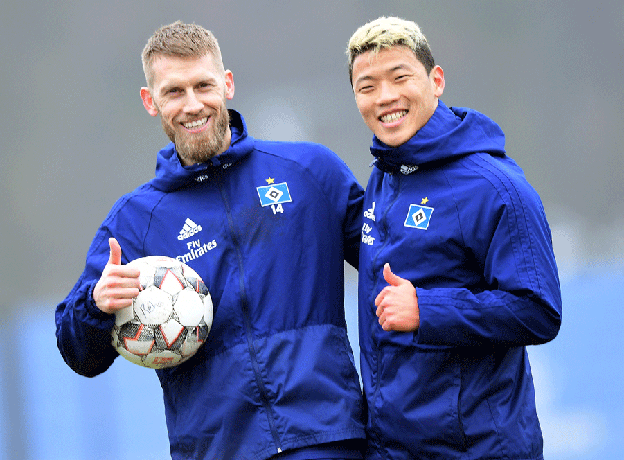 Aaron Hunt und Hee-chan Hwang stehen nebeneinander und lachen in die Kamera.