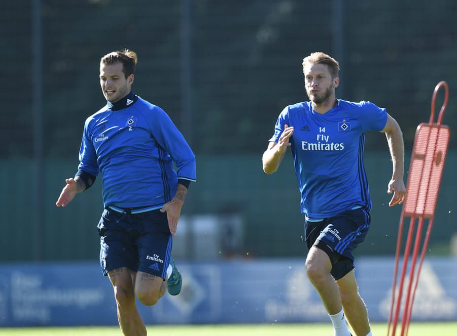 Dennis Diekmeier and Aaron Hunt sprint during training.