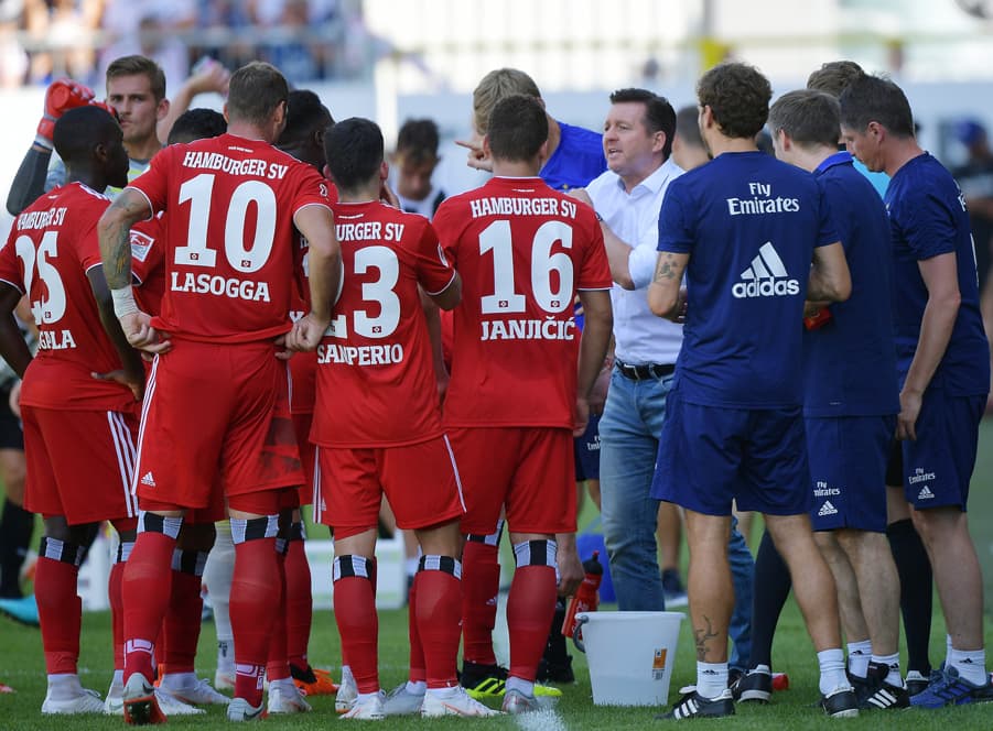 Christian Titz hat die Spieler nach dem Spiel in Sandhausen zu einem Kreis zusammengeholt und spricht zu ihnen. 
