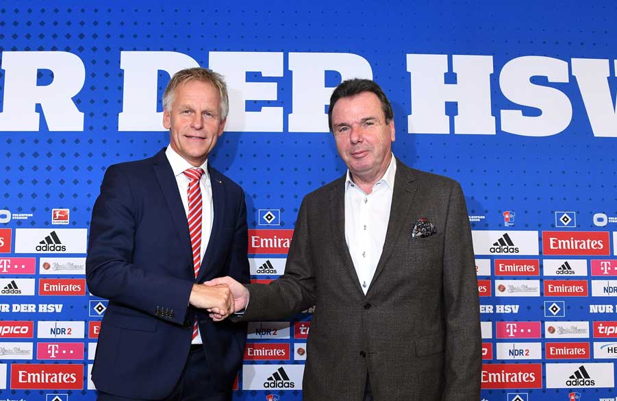 Heribert Bruchhagen und Jens Meier schütteln sich auf dem Podium die Hand.