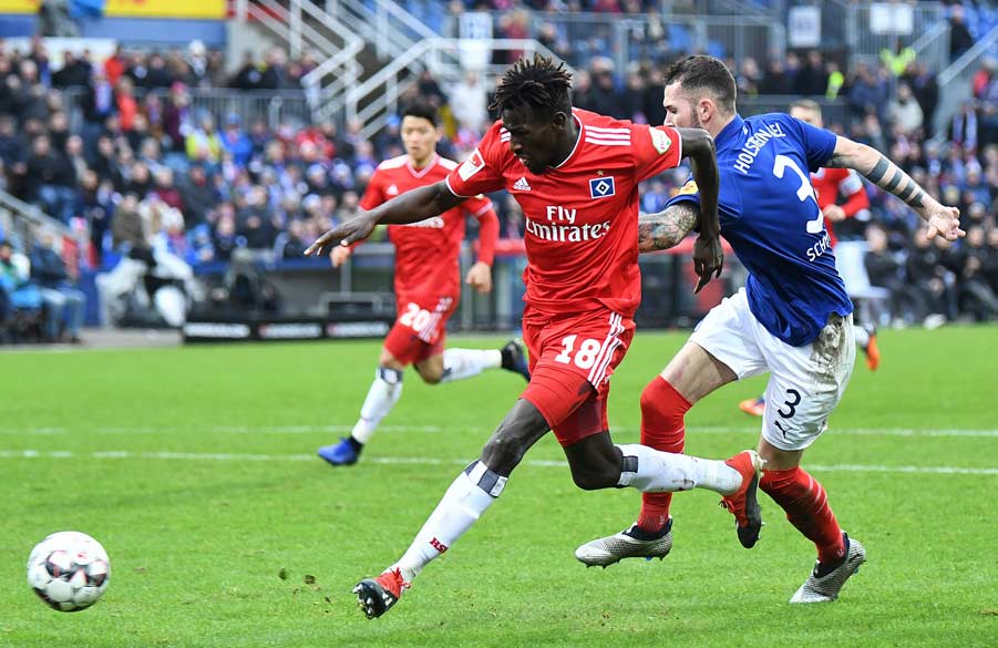 Jatta setzt sich mit Ball im Laufduell gegen Schmidt durch.