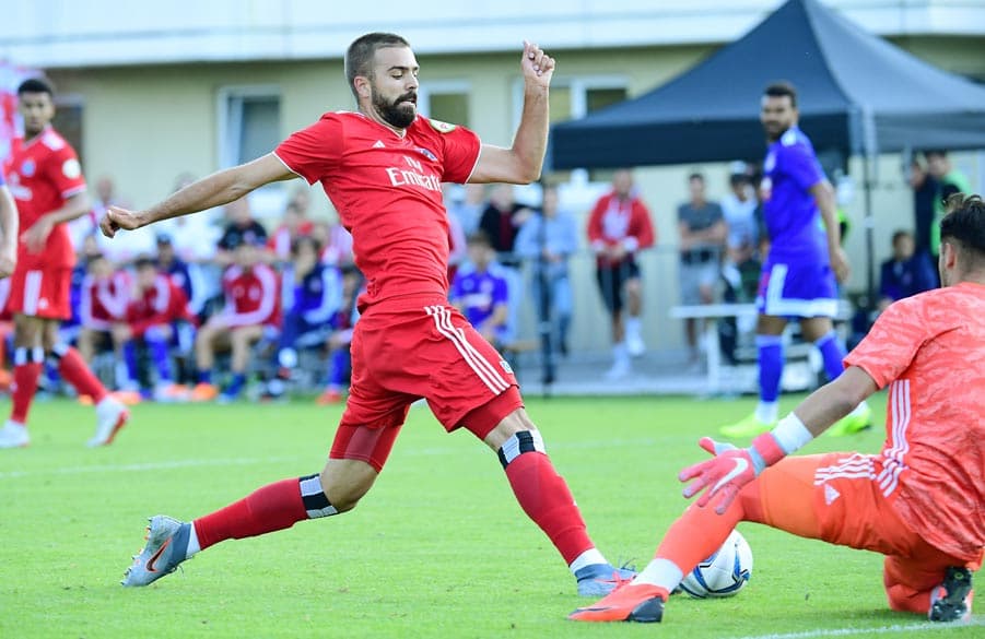 HIntersser spielt den Ball am Keeper von Olympiakos vorbei.