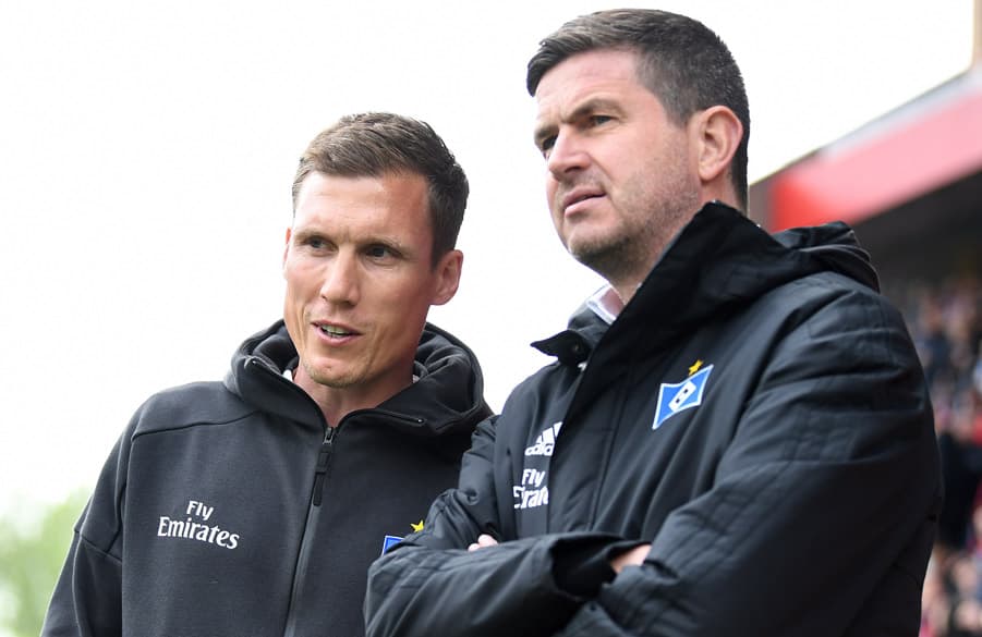 Ralf Becker und Hannes Wolf stehen nebeneinander.