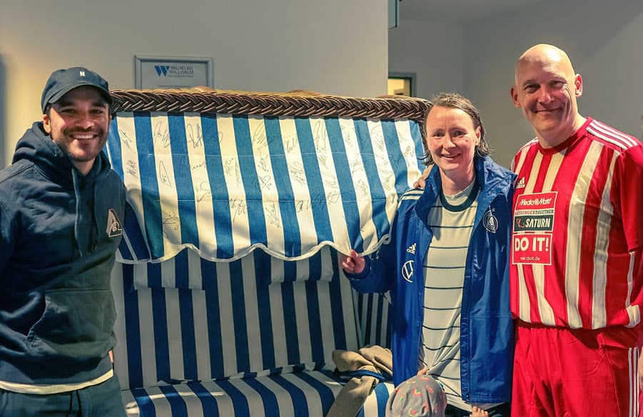 Schauspieler Kostja Ullmann, Frauenfußball-Legende Conny Pohlers, HSV-Unikat Thomas Gravesen (v.l.) und alle anderen Teilnehmer haben den Strandkorb unterschrieben.