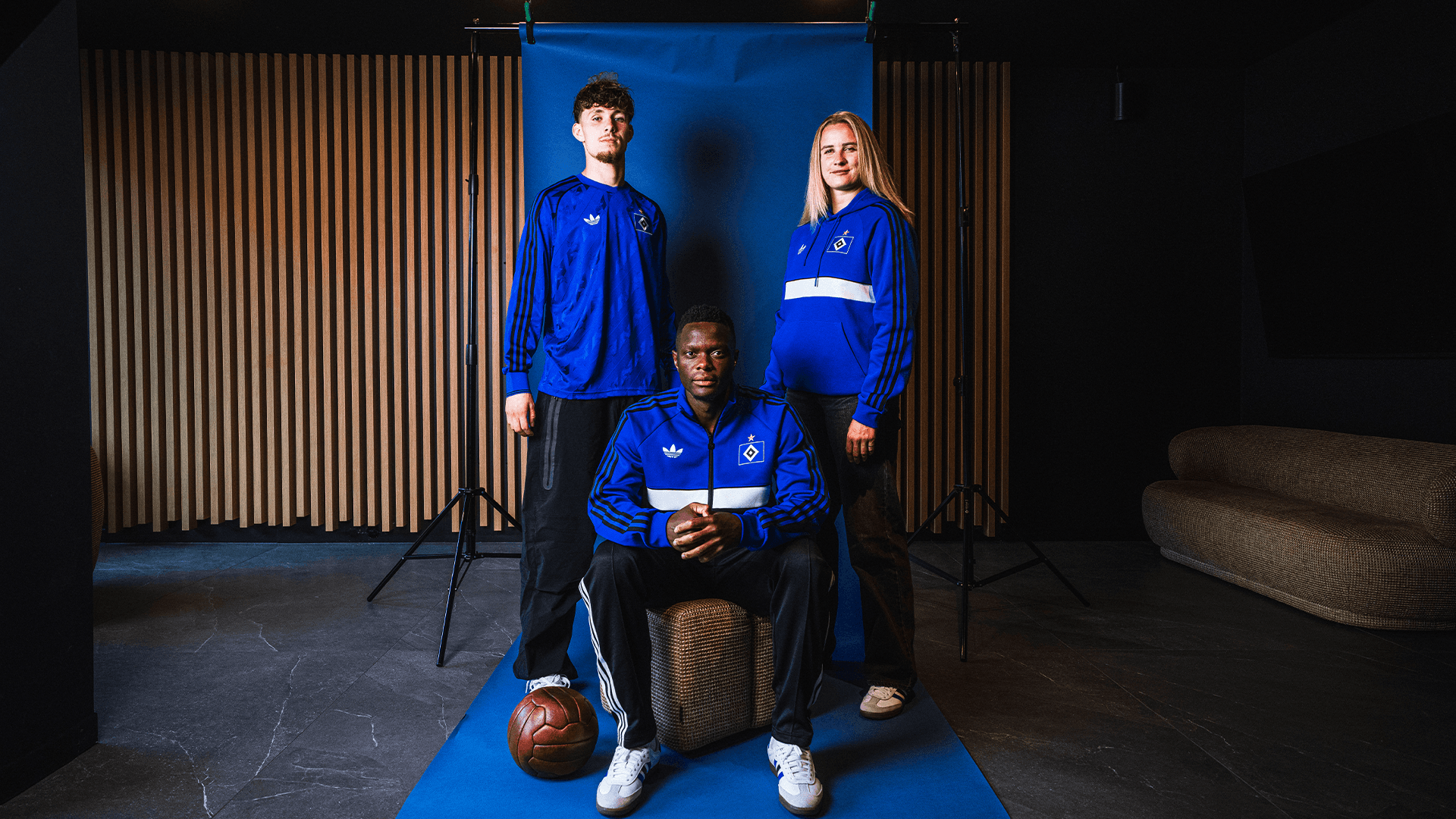 Spieler und Spielerin des HSV posieren in adidas Klamotten.