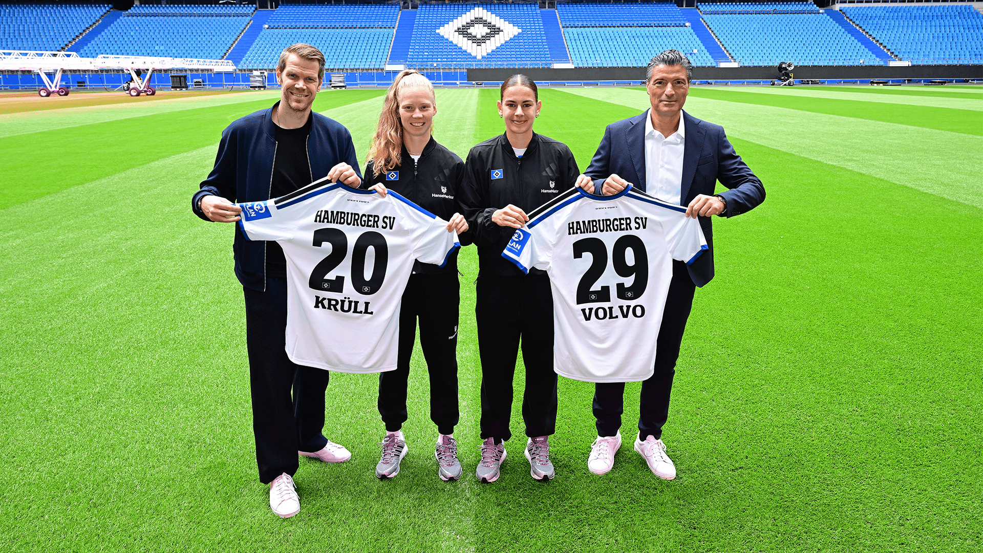HSV-Vorstand und Krüll Volvo Geschäftsführer posieren mit zwei Spielerinnen des HSV und zwei Trikots.