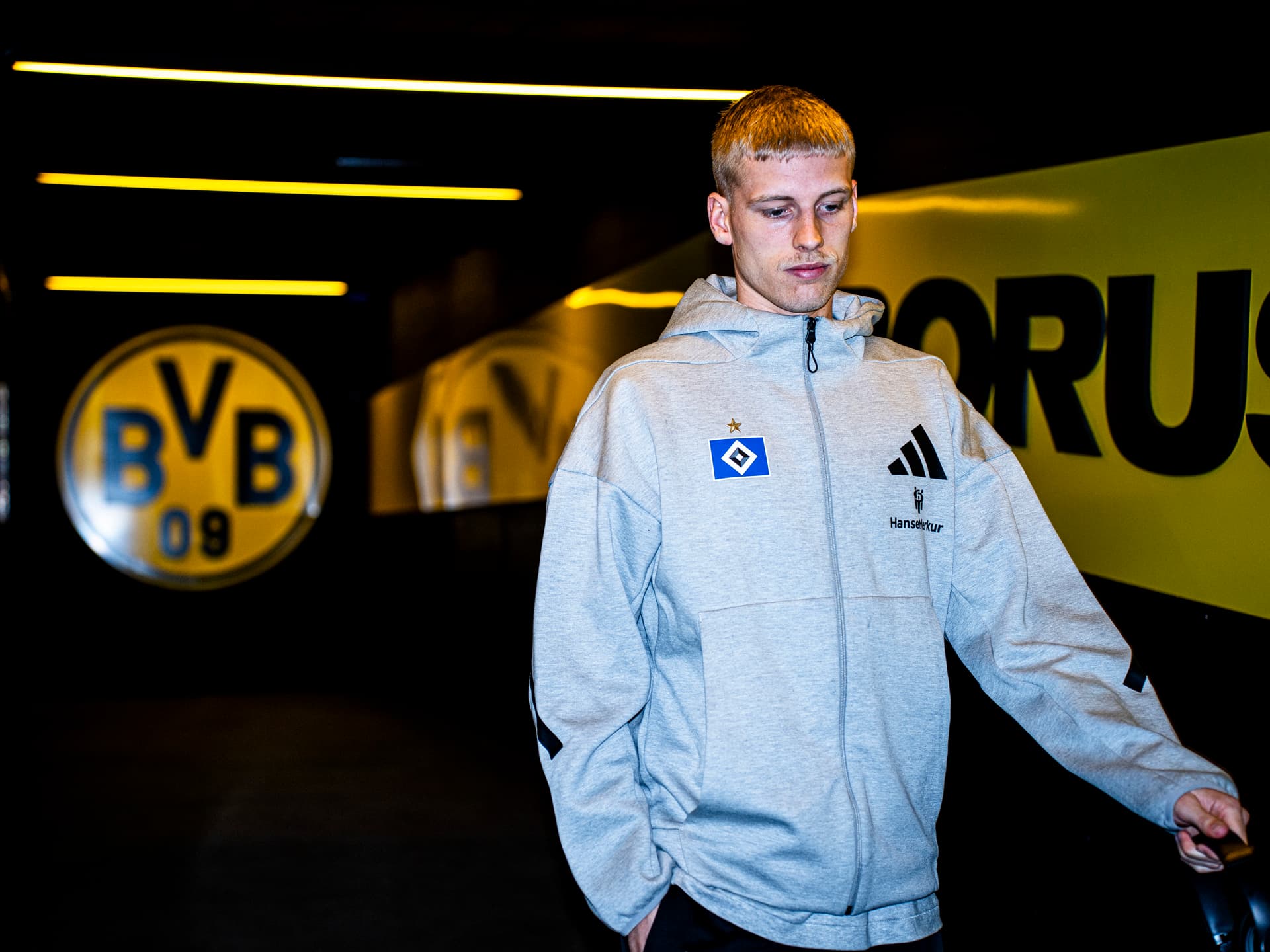 Allbert Grönbaek läuft durch den Spielertunnel in Dortmund. Im Hintergrund ist das BVB-Logo groß zu sehen.