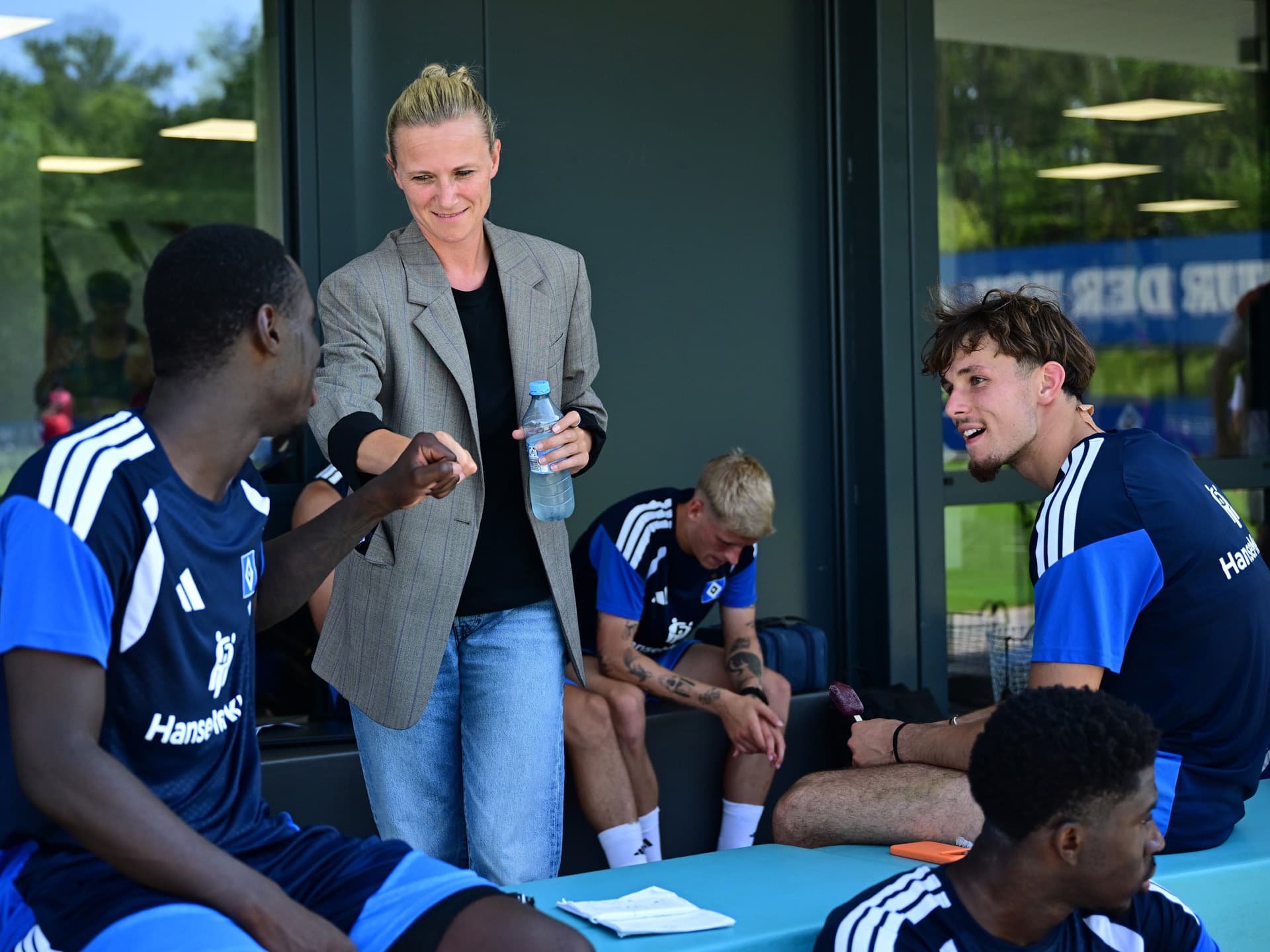 Kathleen Krüger begrüßt Spieler im HSV-Trainingslager in Herzogenaurach