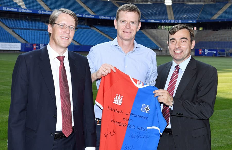 HSV-Marketing Vorstand Joachim Hilke (Mitte) übergibt Roland Kirsch (li., Reyher) und Dr. Peter Bielert (Geschäftsführer Reyher) das Trikot des Hamburger Wegs.