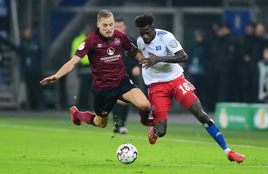 Bakery Jatta schüttelt im Sprintduell FCN-Kapitän Hanno Behrens ab.