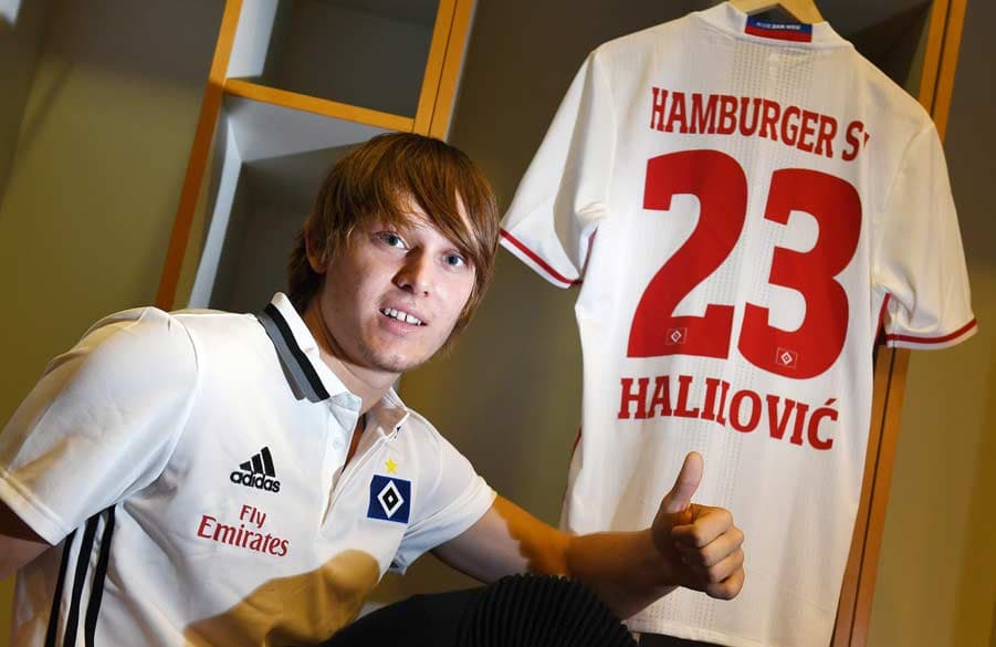 Alen Halilovic sitzt in der Kabine vor seinem HSV-Trikot mit der Nr. 23.