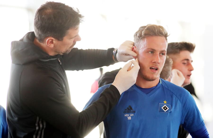 Athletik-Trainer Jan Hasenkamp (li.) entnimmt U21-Kapitän Dennis Strompen Blut.