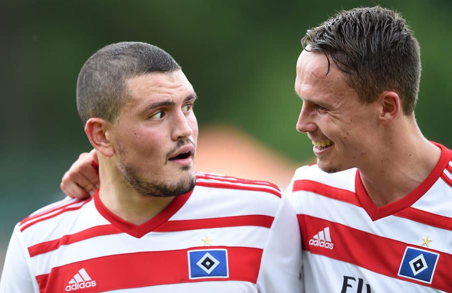 Kyriakos Papadopoulos und Bjarne Thoelke lachen zusammen auf dem Platz.