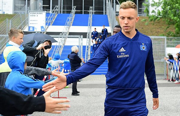 Kittel klatscht mit einem Fan am Trainingsplatz ab.