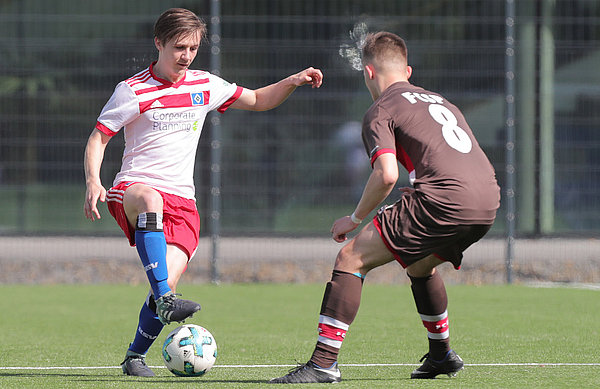 HSV-Spieler Justin Jaeger mit einem Übersteiger vor einem Abwehrspieler von St. Pauli. 