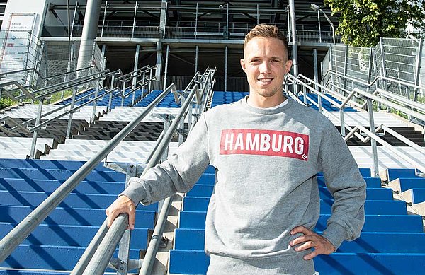 Sonny Kittel steht mit Hamburg-Pullover vor dem Stadioneingang des Volksparkstadions.