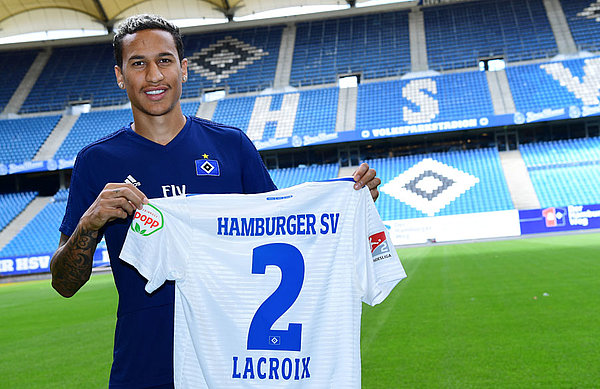 Leo Lacroix erhält beim HSV die Rückennummer 2. Leo Lacroix steht im Stadion mit einem HSV-Trikot mit der Rückennummer 2.