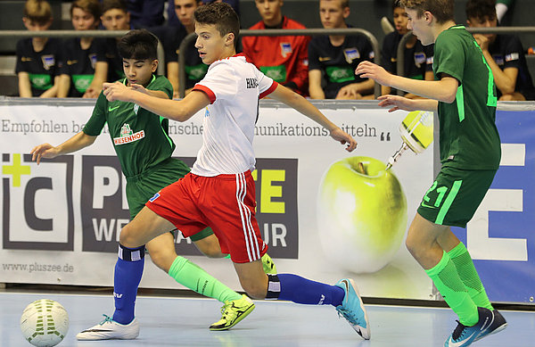 Der Hamburger U15-Angreifer setzt sich mit dem Ball in der Halle gegen seine Gegenspieler durch.