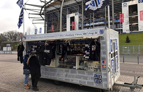 An Volkspark-Heimspielen mit Zuschauern stehen die Mitarbeiter von 1887 Streetwear in mehreren Verkaufsanhängern rund um das Volksparkstadion - hier direkt vor der Nordtribüne.