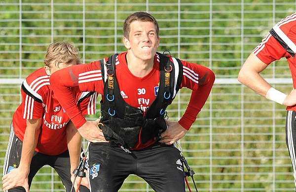 Alexander Brunst steht mit einer Weste und Seilen auf dem Trainingsplatz.