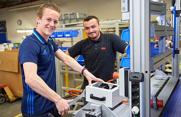 Jonas Behounek (l.) bei der Arbeit. WISKA-Arbeiter Mustafa Ashim erklärt dem HSV-Jungprofi, was er machen muss. 