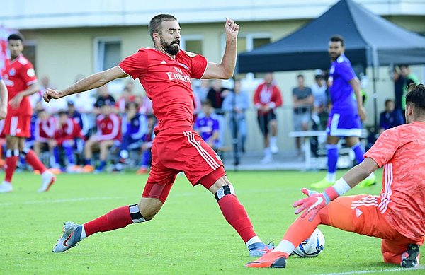 HIntersser spielt den Ball am Keeper von Olympiakos vorbei. 