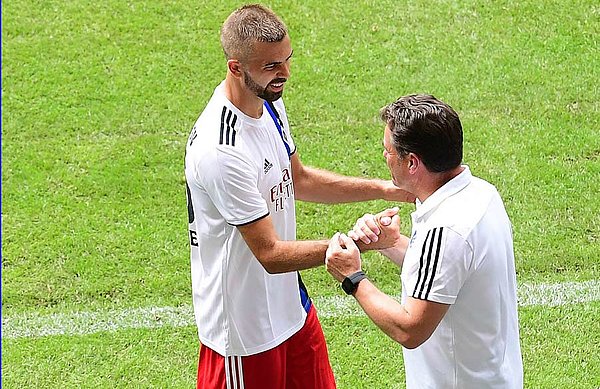 Dieter Hecking steht am Spielfeldrand und klatscht mit Lukas Hinterseer ab.