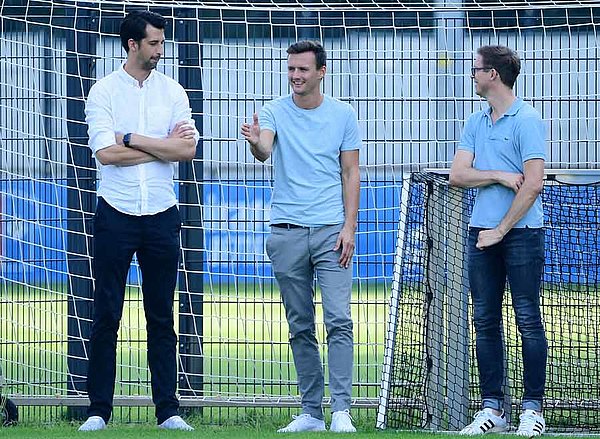 Teamwork: Jonas Boldt (li.) setzt weiter auf die Zusammenarbeit mit Claus Costa (mi.) und Michael Mutzel (re.). Jonas Boldt steht am Trainingsplatz zusammen mit Claus Costa und Michael Mutzel.