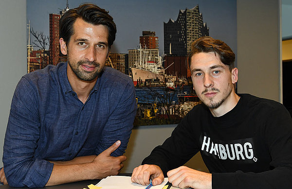 Jonas Boldt und Adrian Fein sitzen am Tisch bei der Vertragsunterschrift.