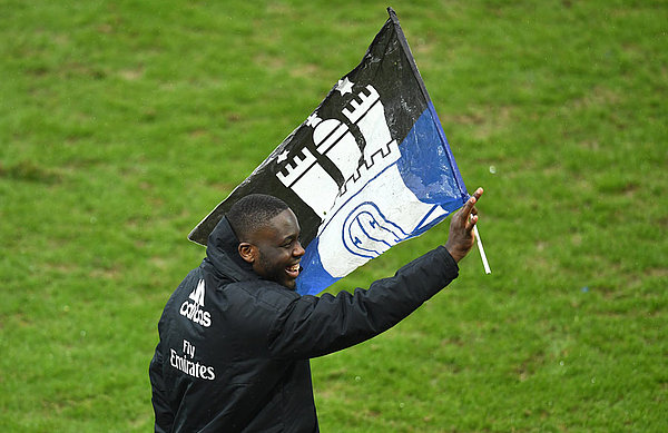 Orel Mangala schwenkt eine HSV-Fahne.