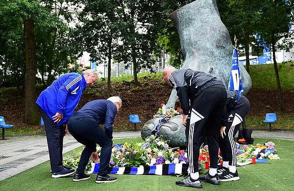 Hrubesch, Wehmeyer, Walter und Schonlau legen Blumen für Uwe Seeler nieder.