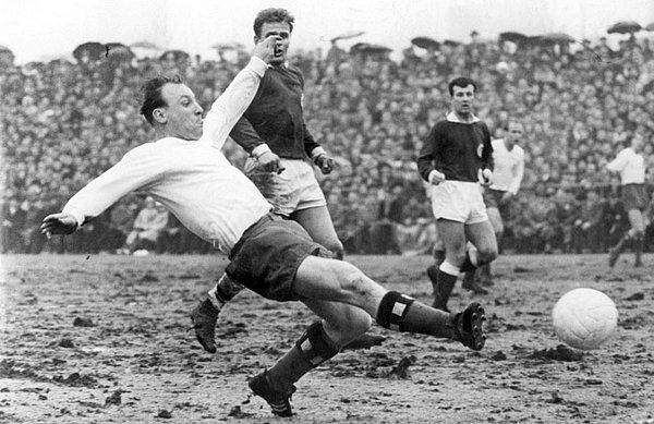 Uwe Seeler, noch als aktiver Spieler, bei einer Grätsche um den Ball.