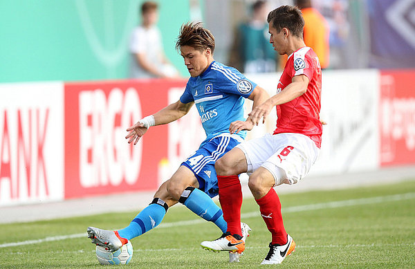 Gotoku Sakai schirmt im Zweikampf den Ball vor seinem Gegenspieler ab.