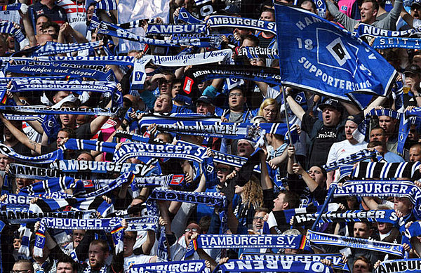 Die Fans des HSV stehen in guten wie auch in schwierigen Zeiten zu ihrem Verein. HSV-Fans mit Fanschals auf der Tribüne.