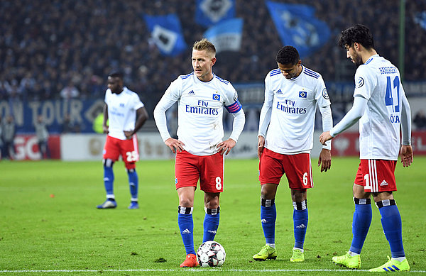 Lewis Holtby, Douglas Santos und Berkay Özcan stehen zur Ausführung eines Freistoßes bereit. 