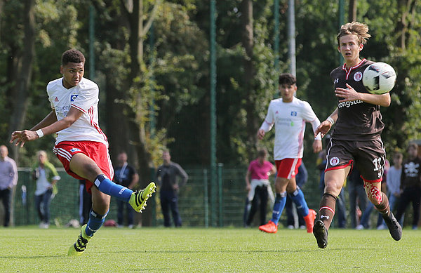 Saibo Ibraimo schießt den Ball am Pauli-Spieler vorbei.