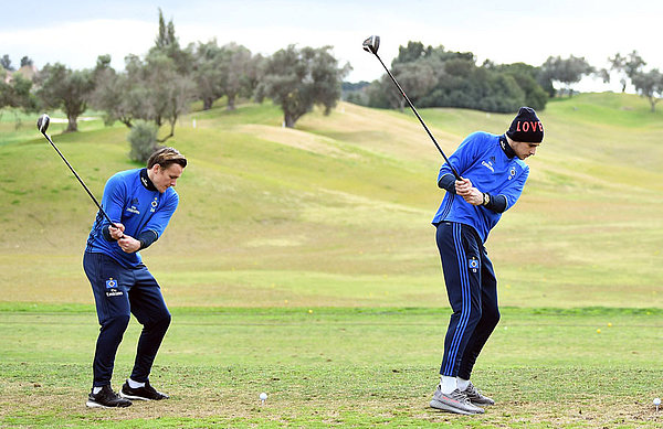Tom Mickel und Julian Pollersbeck schlagen Golfbälle weg.